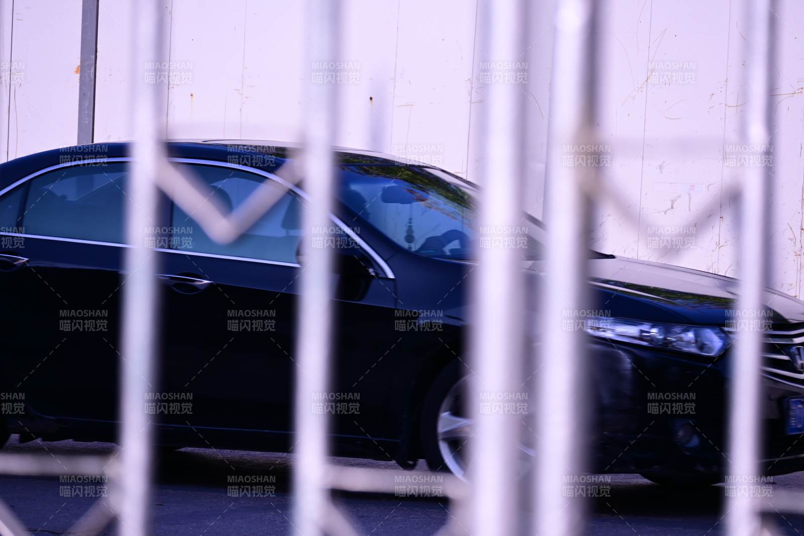 铁栅栏后的黑色轿车图片