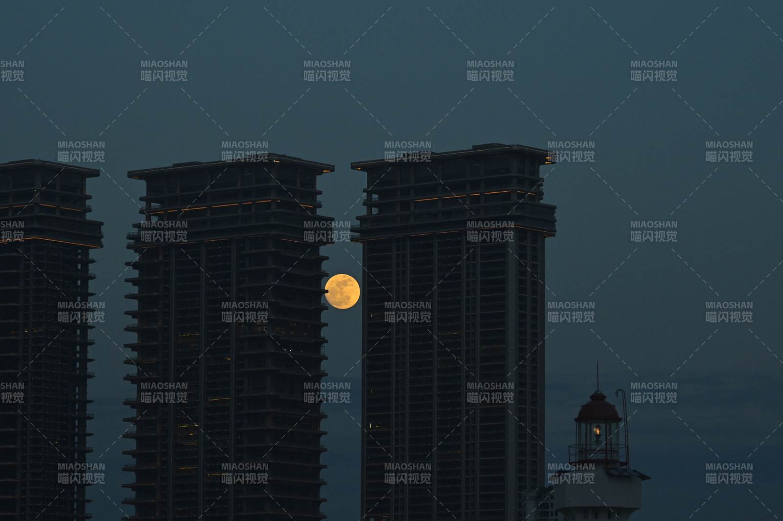 高楼间明月 灯塔映夜空图片