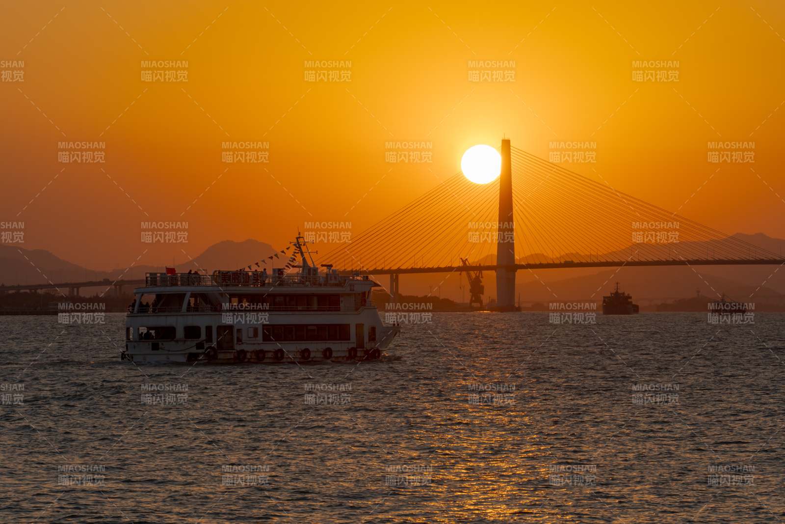夕阳下的跨海大桥与游船图片
