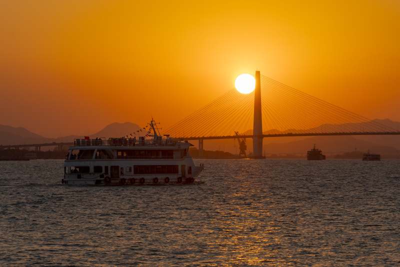 夕阳下的跨海大桥与游船图片