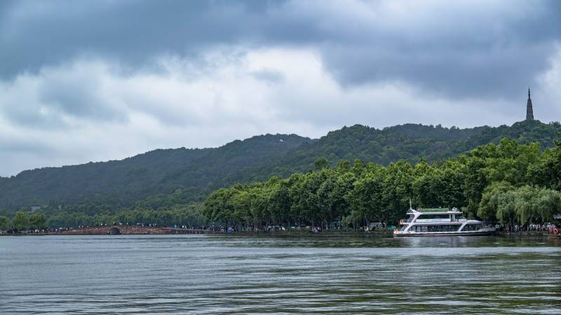 西湖游船与远山景色图片