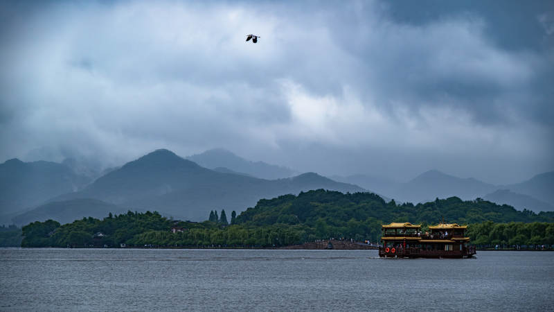 西湖雨景 游船悠然图片