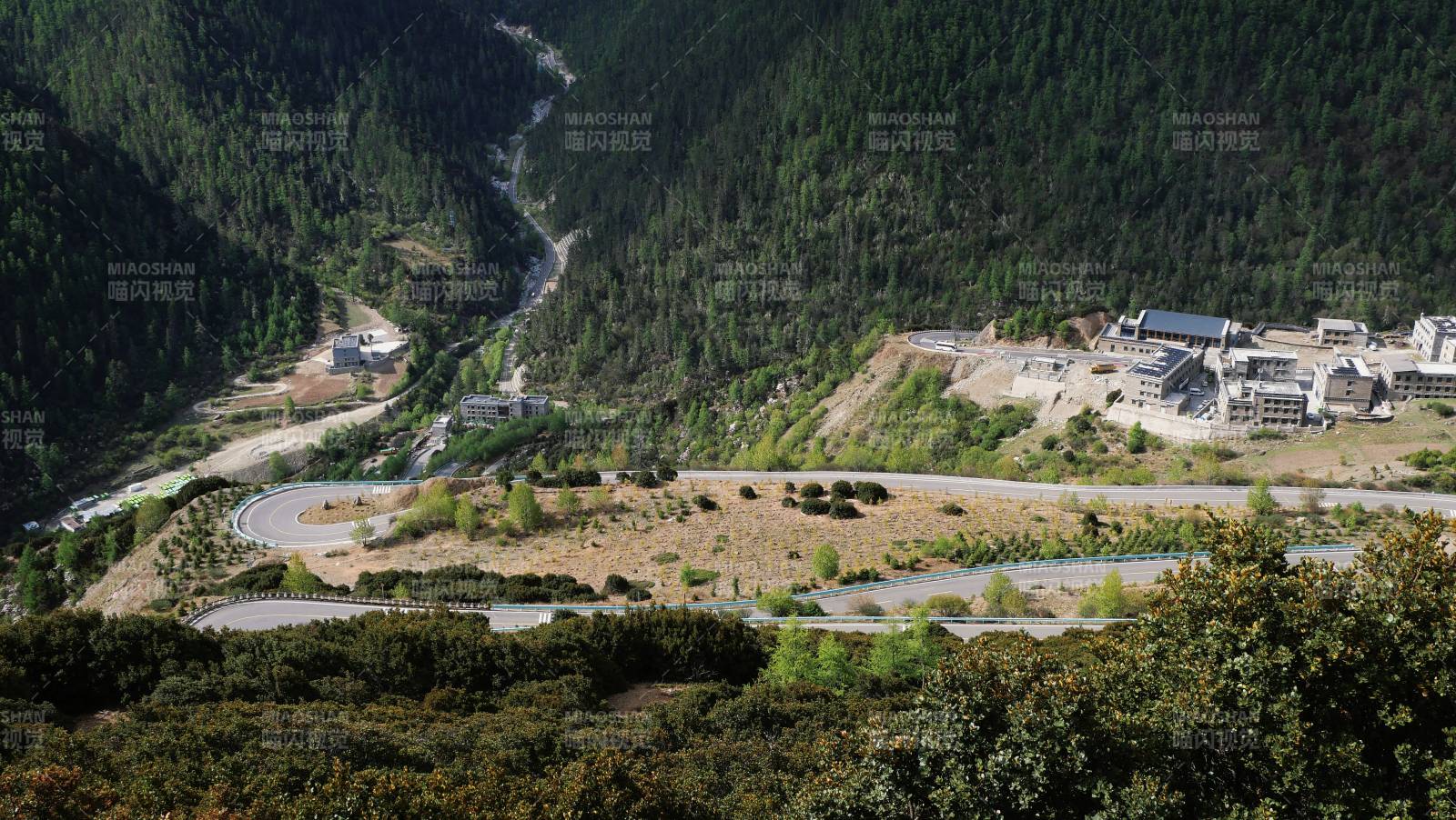 山谷中的蜿蜒公路与建筑群图片