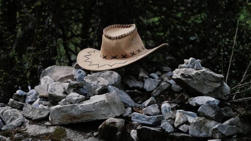 牛仔帽与石堆的静谧时光图片