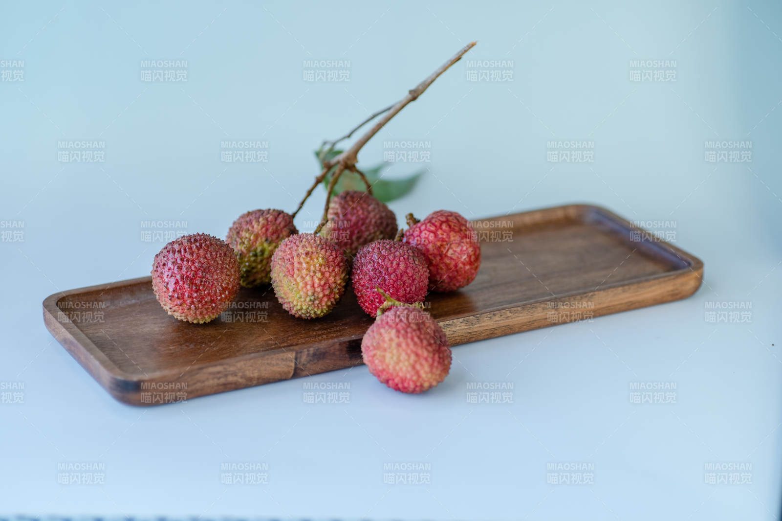 新鲜荔枝静置木盘上图片