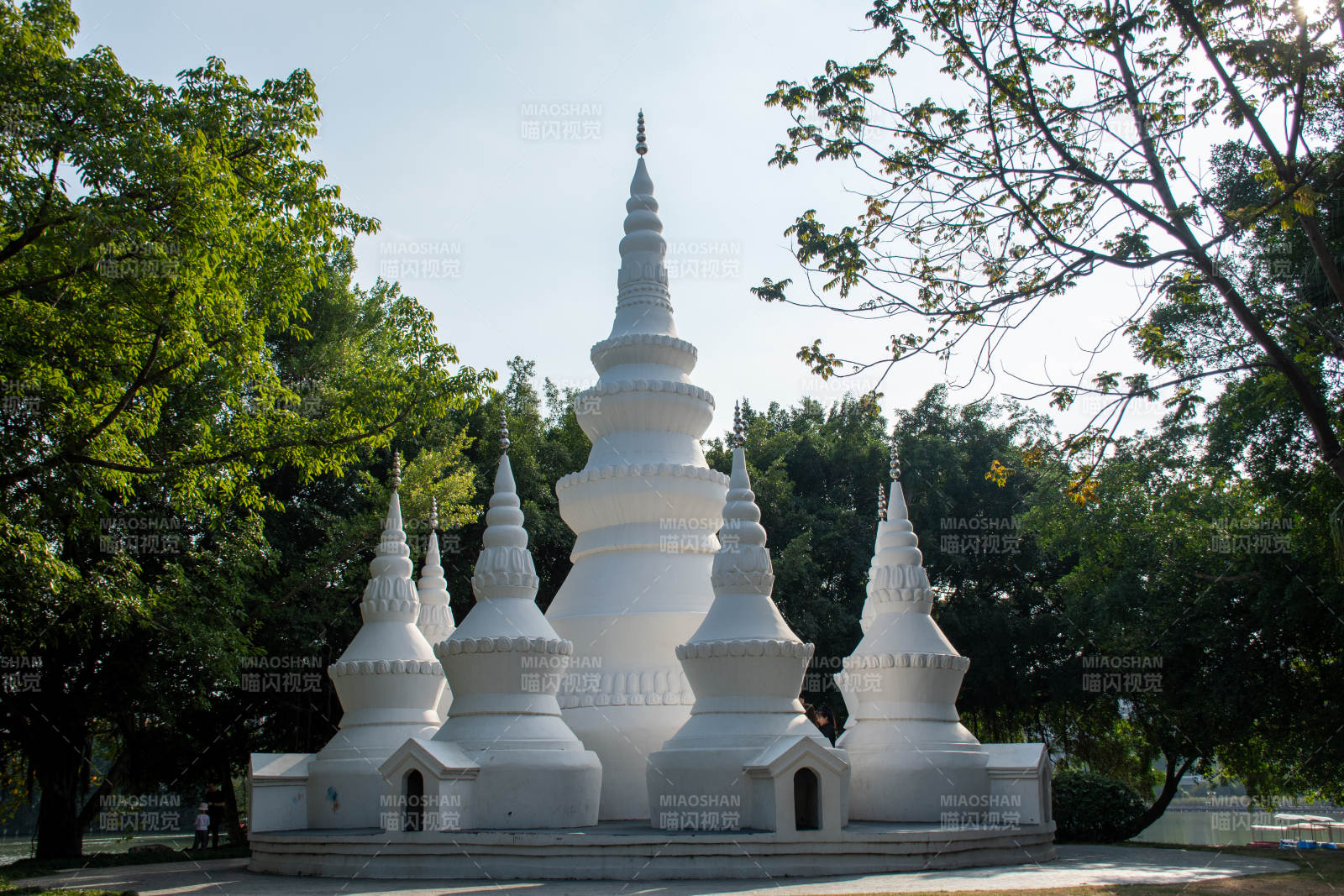 白色佛塔群与绿树相映图片