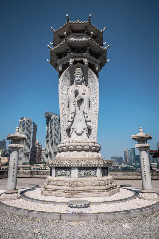 观音雕像与城市天际线图片