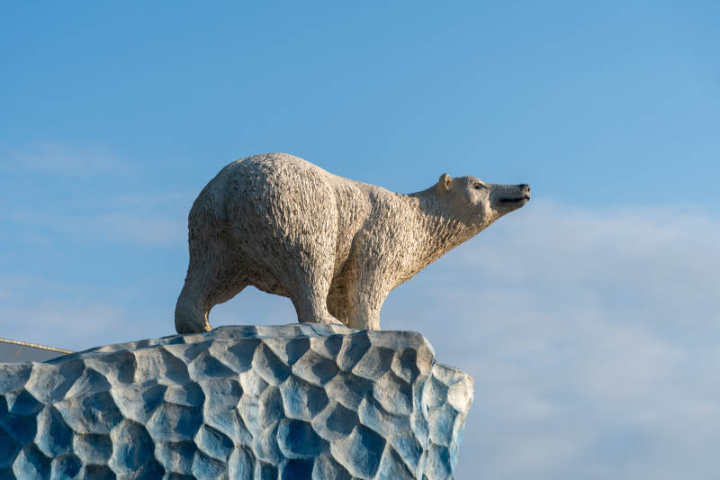 北极熊雕像矗立冰岩上图片