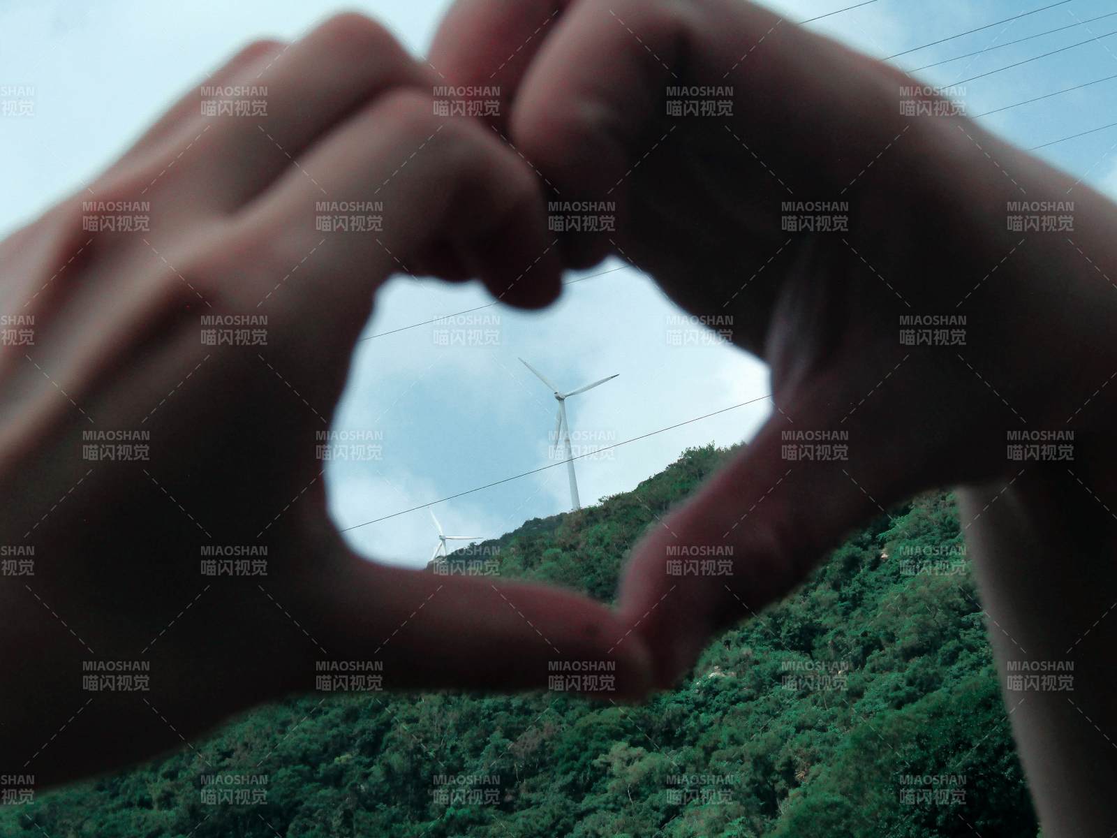心形手势与风车山景图片