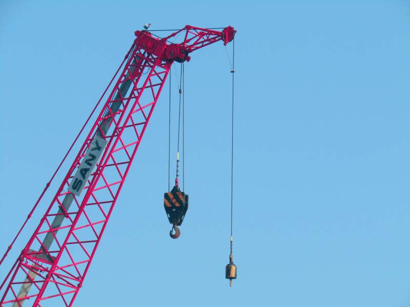 红色起重机吊装作业中图片