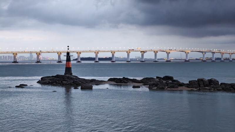 海中灯塔与大桥远景图片
