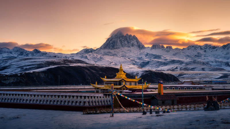 雪山下的金色寺庙图片
