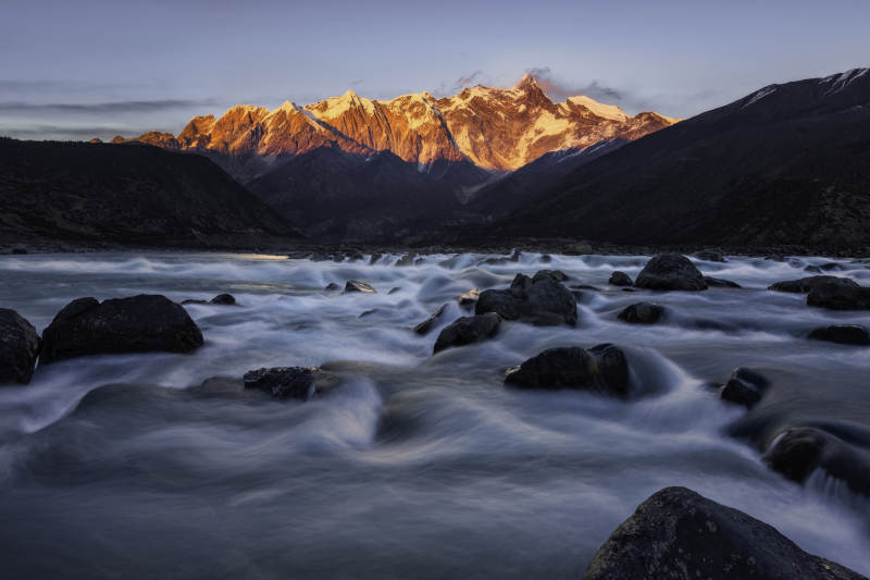 雪山下的湍流河景图片