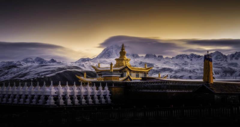 雪山下的金色寺庙图片