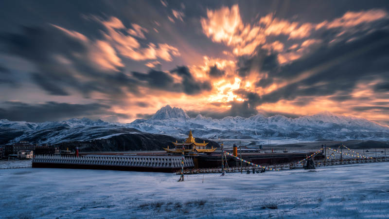 雪山下的金色寺庙图片