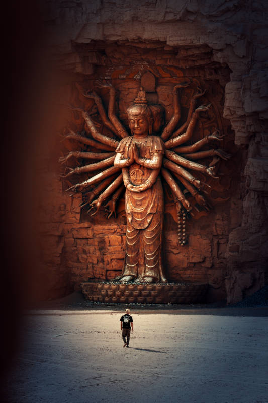 千手观音雕像前的行人图片