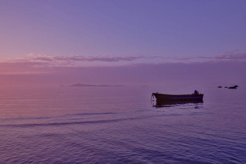 暮色中的孤舟静谧海面图片