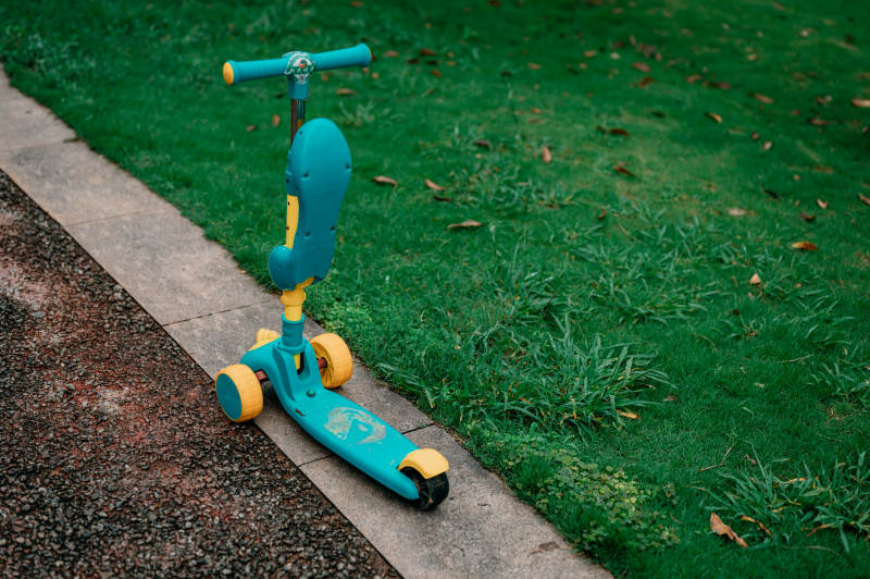 草地旁的蓝色滑板车图片