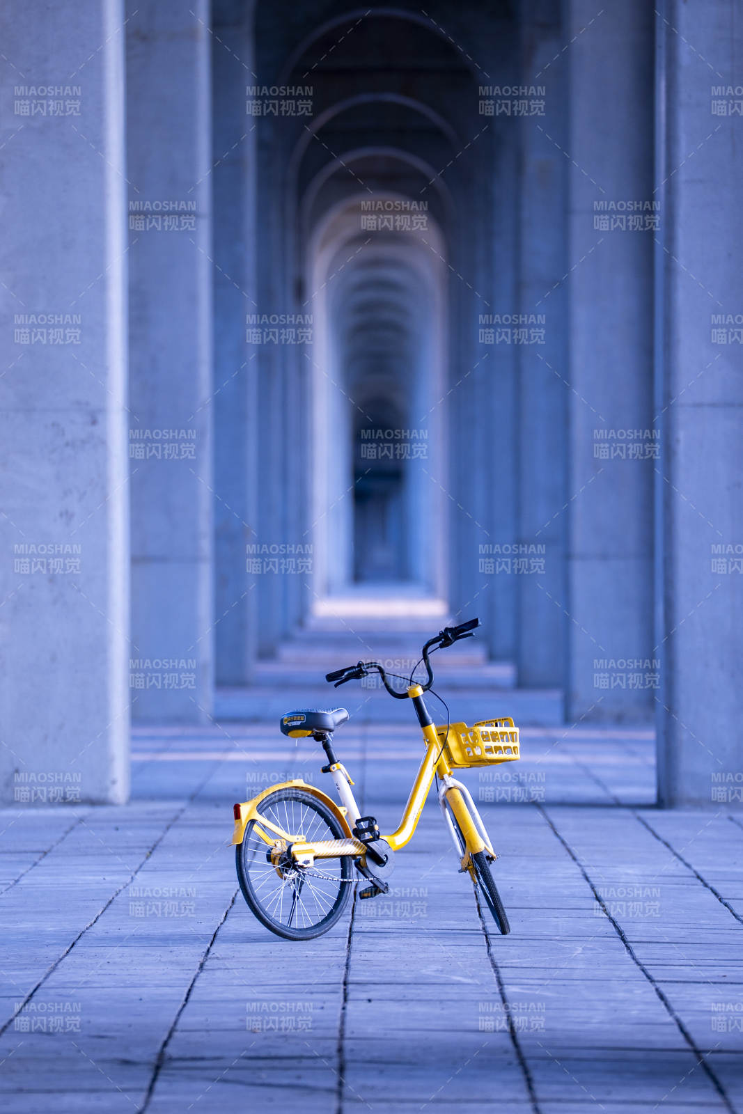 黄色共享单车在拱廊下图片