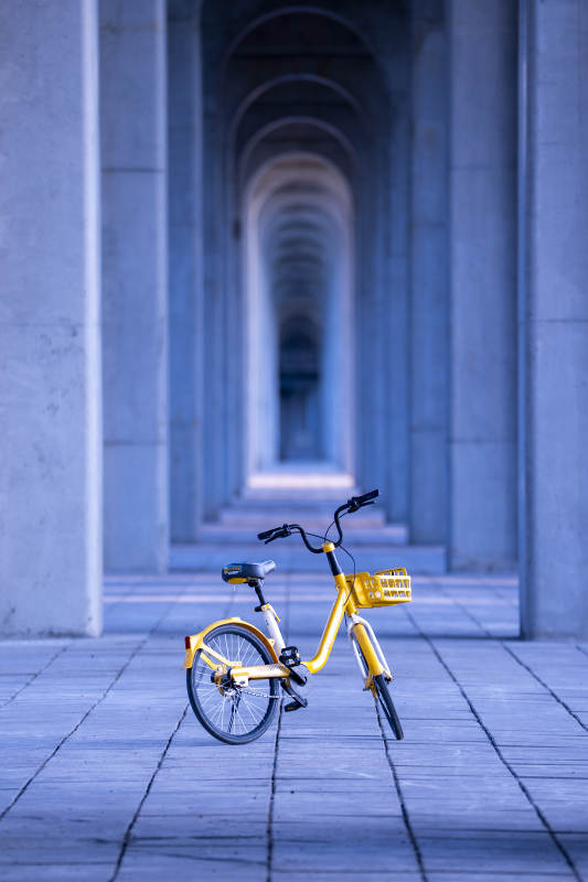 黄色共享单车在拱廊下图片