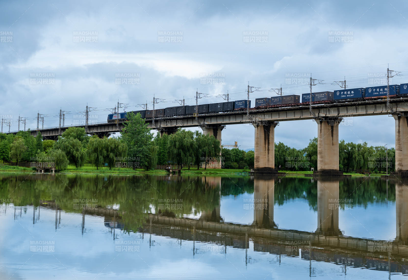 桥上列车 水映蓝天图片
