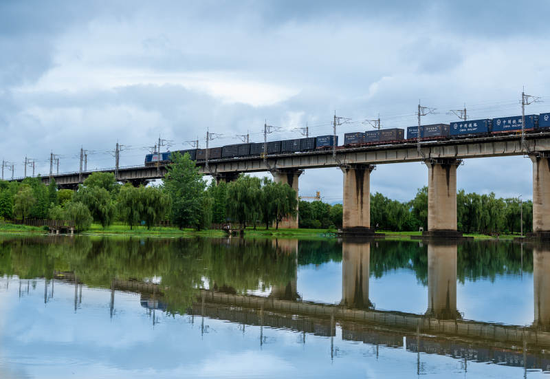桥上列车 水映蓝天图片