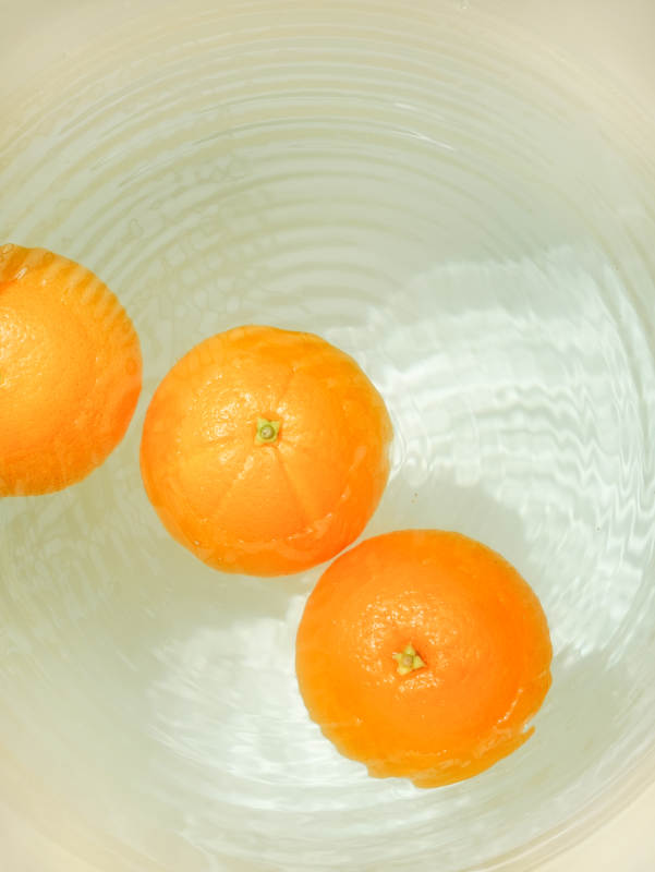 水中漂浮的三个橘子图片