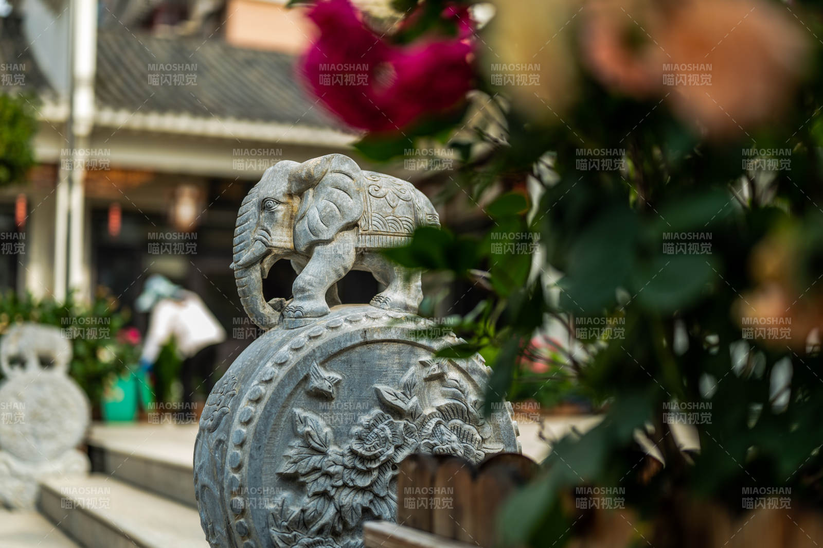 石雕大象与花卉点缀庭院图片