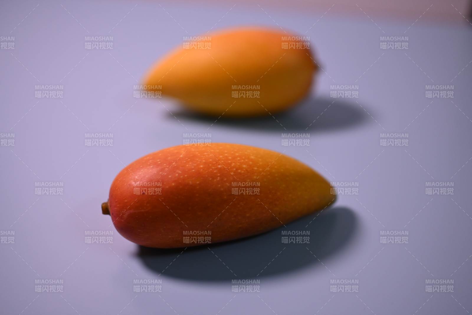 两颗芒果静置于桌面图片