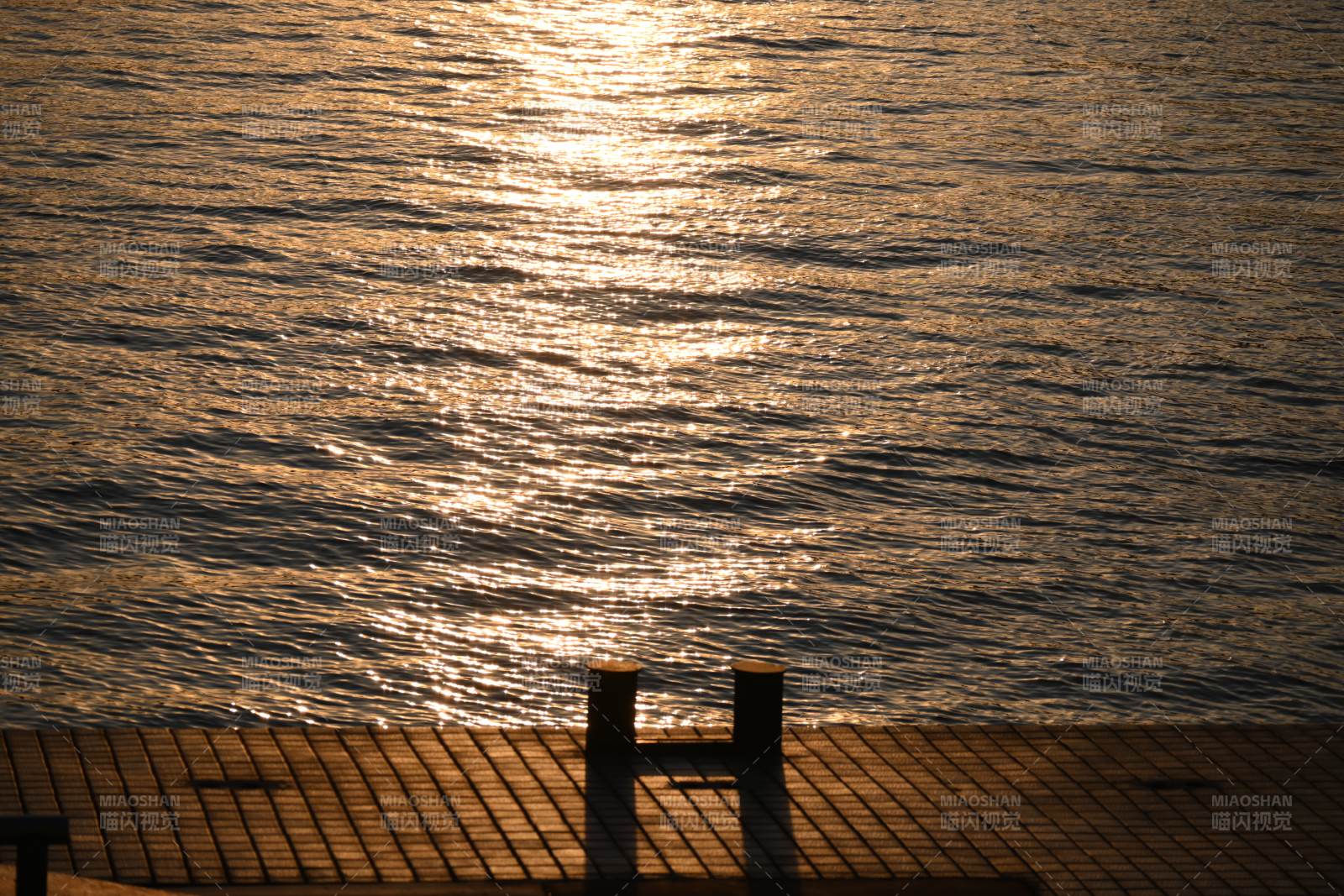 夕阳下的海面与栏杆图片
