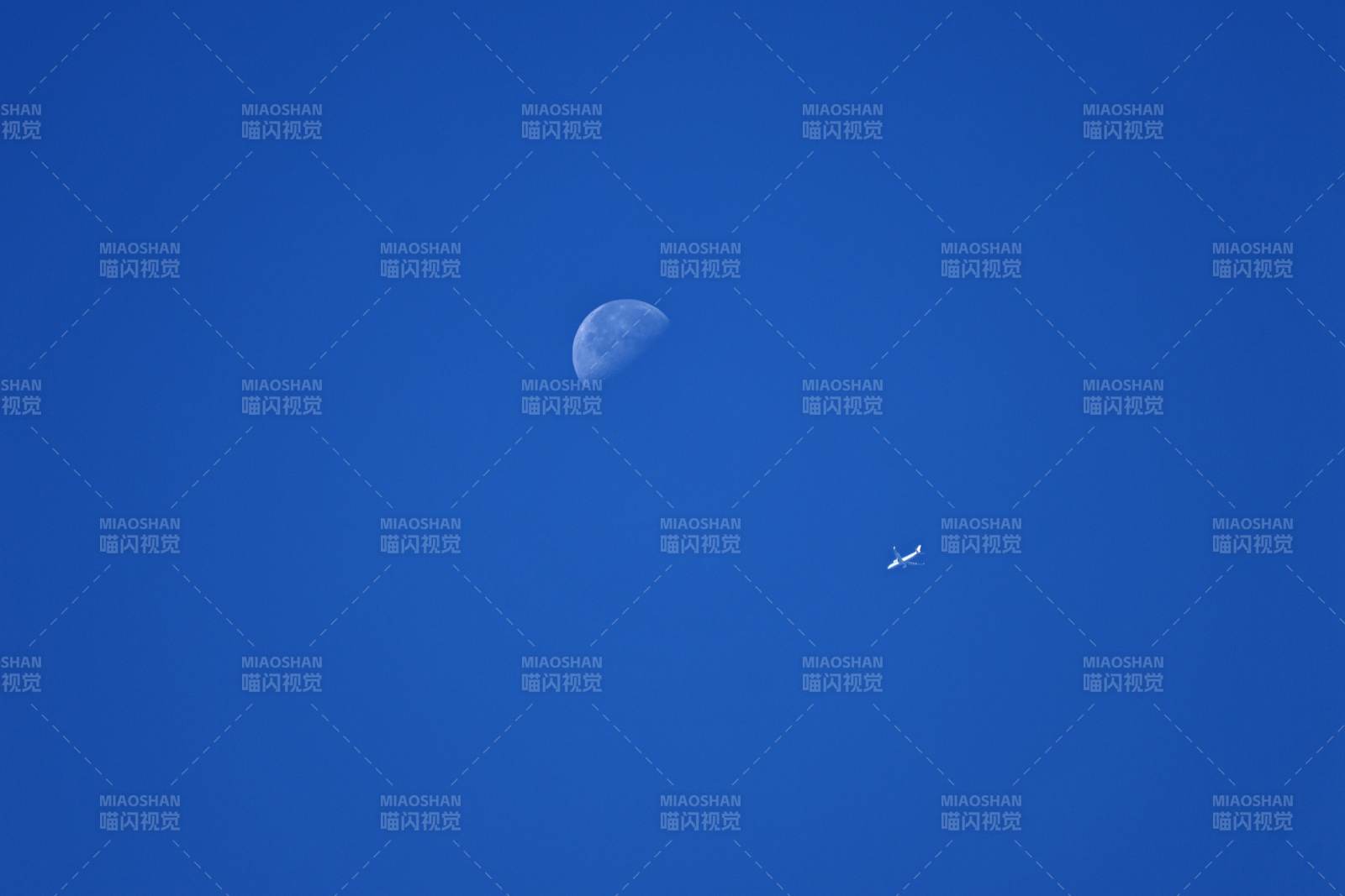 蓝天下的月亮与飞机图片