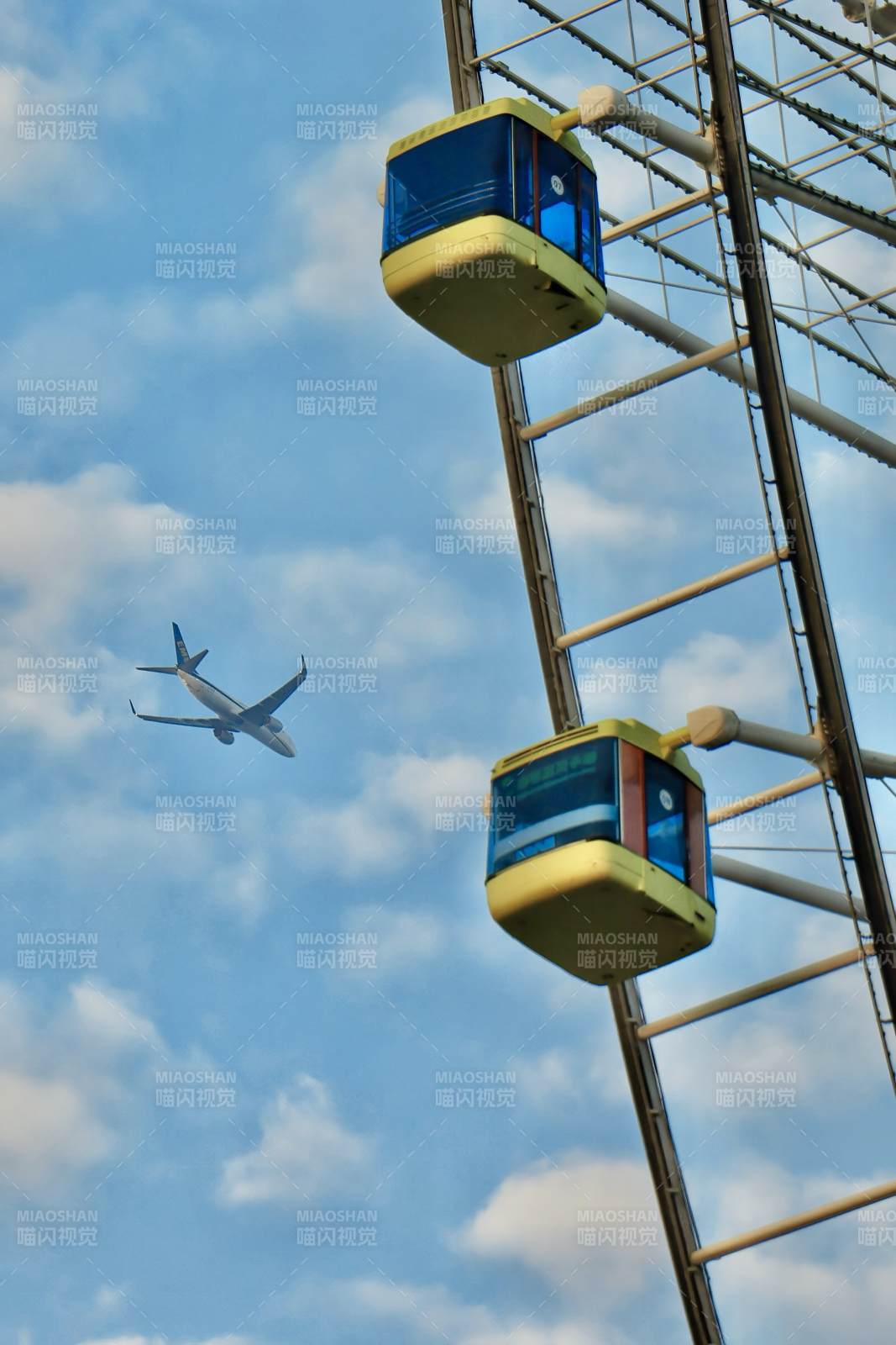 摩天轮与飞行的飞机图片