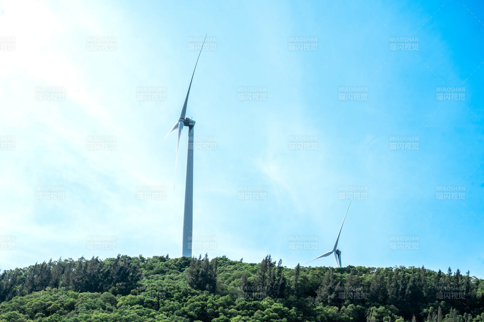 山巅风车 蓝天绿树相映图片