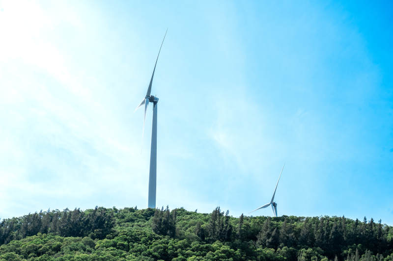 山巅风车 蓝天绿树相映图片