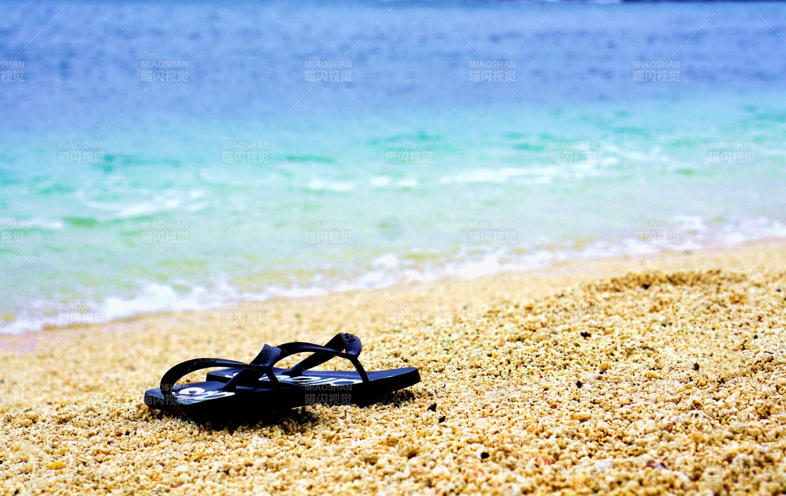 沙滩上的拖鞋与海景图片