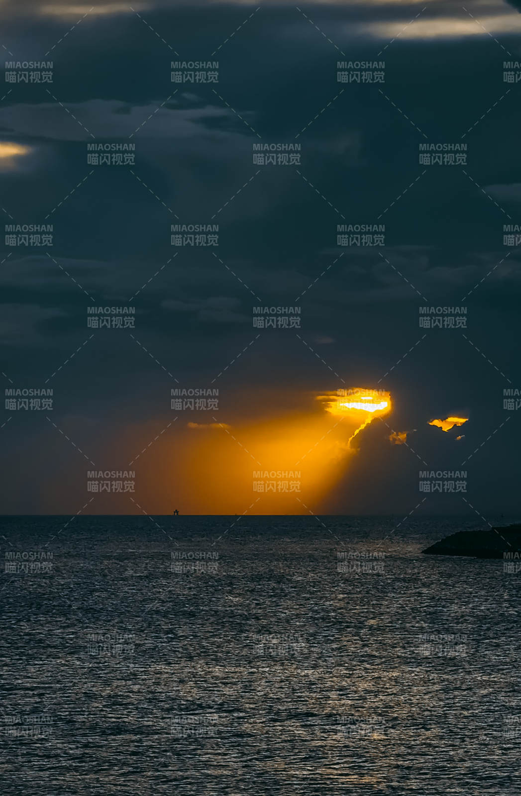 夕阳穿透云层照耀海面图片