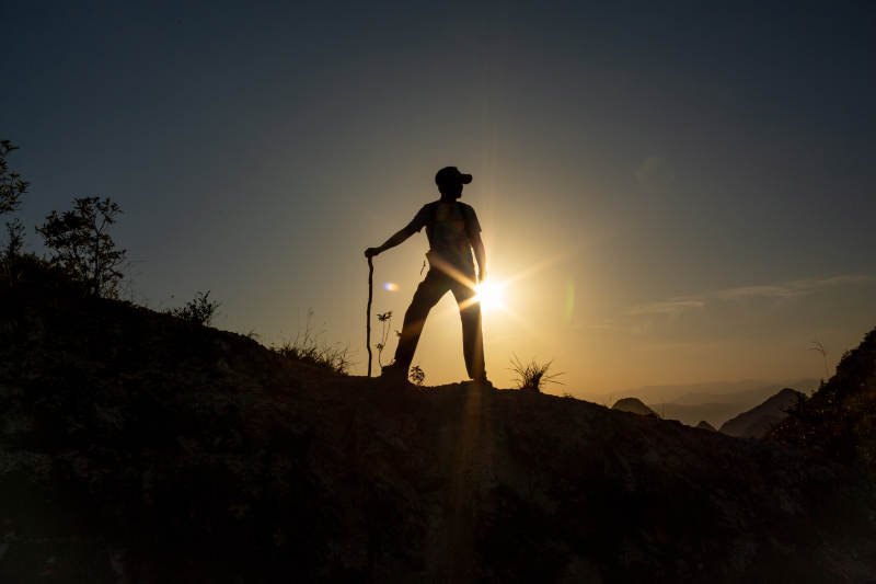 夕阳下的登山者剪影图片