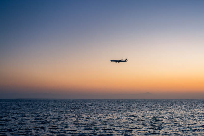 日落时分 飞机掠过海面图片