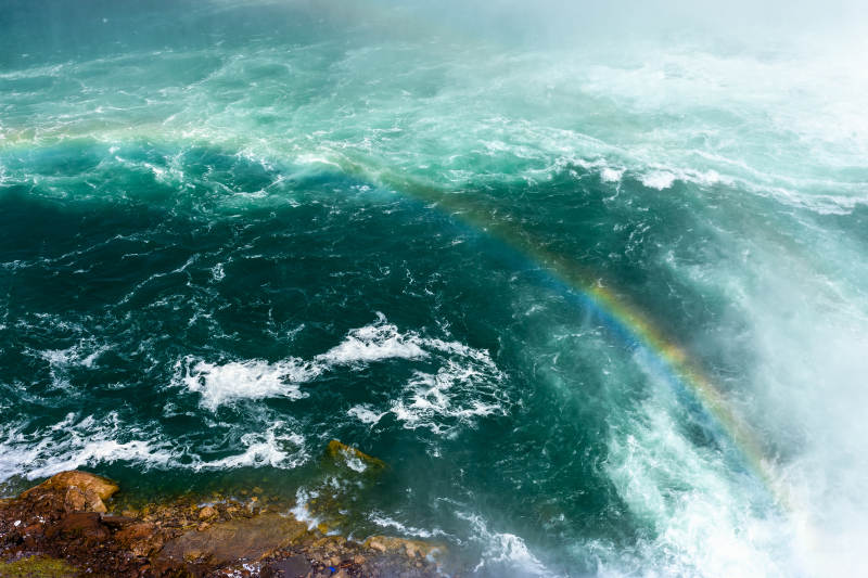 彩虹映照湍流瀑布图片