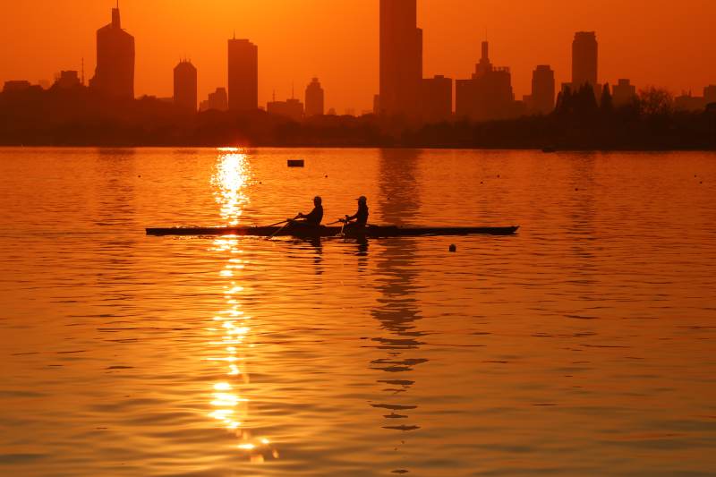 夕阳下的划船剪影图片