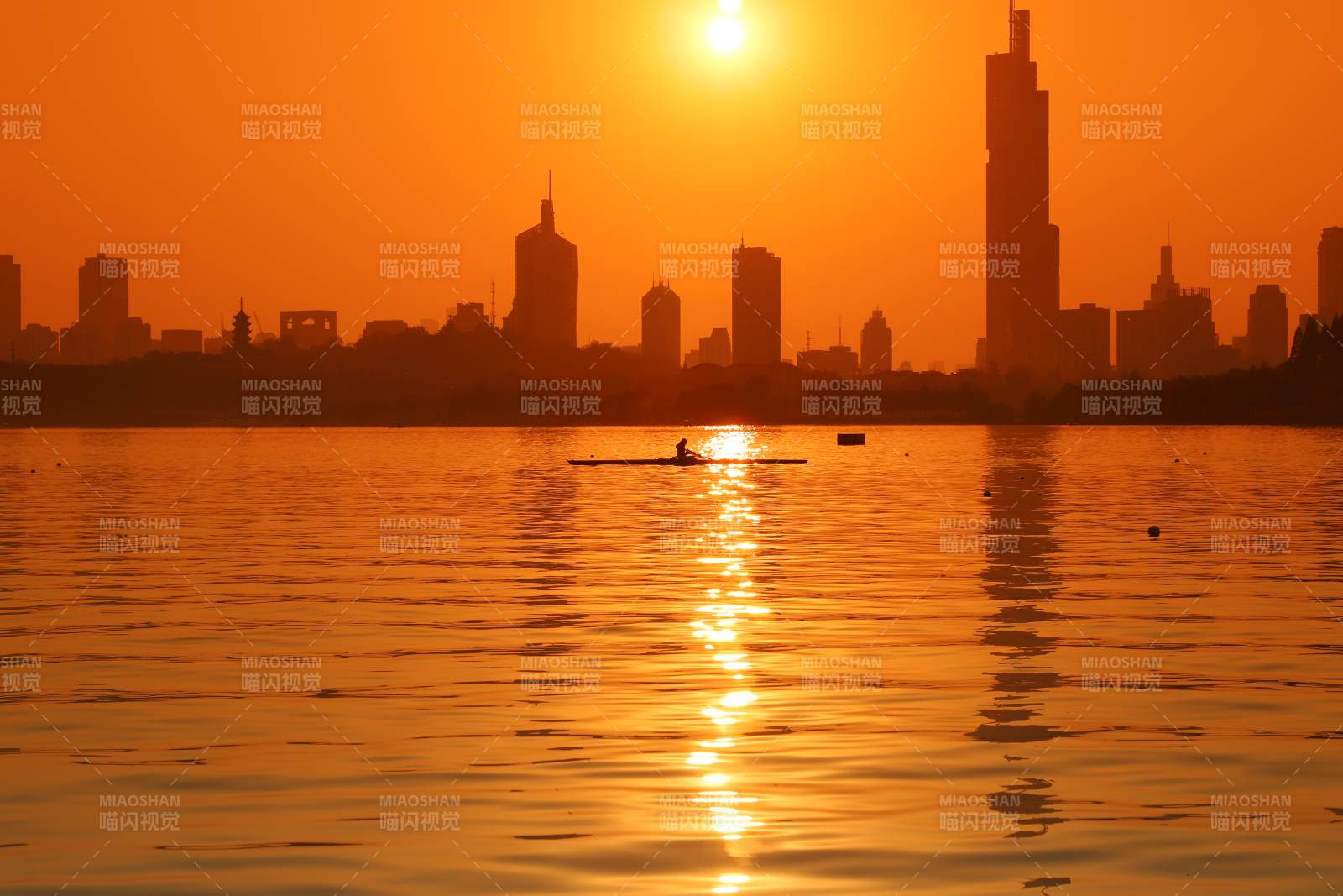 夕阳下的城市与划船者图片