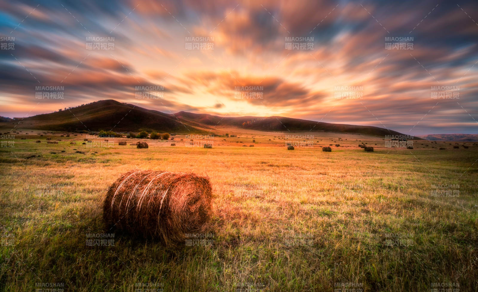 夕阳下的田野与草垛图片