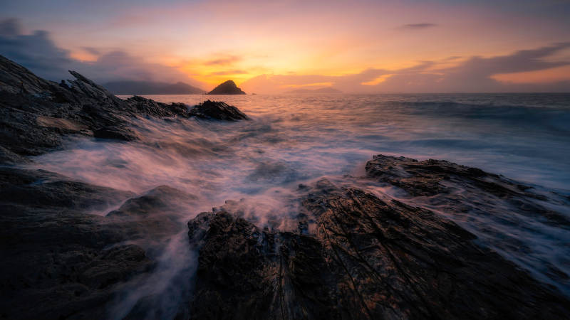 海岸夕阳 波涛拍石图片