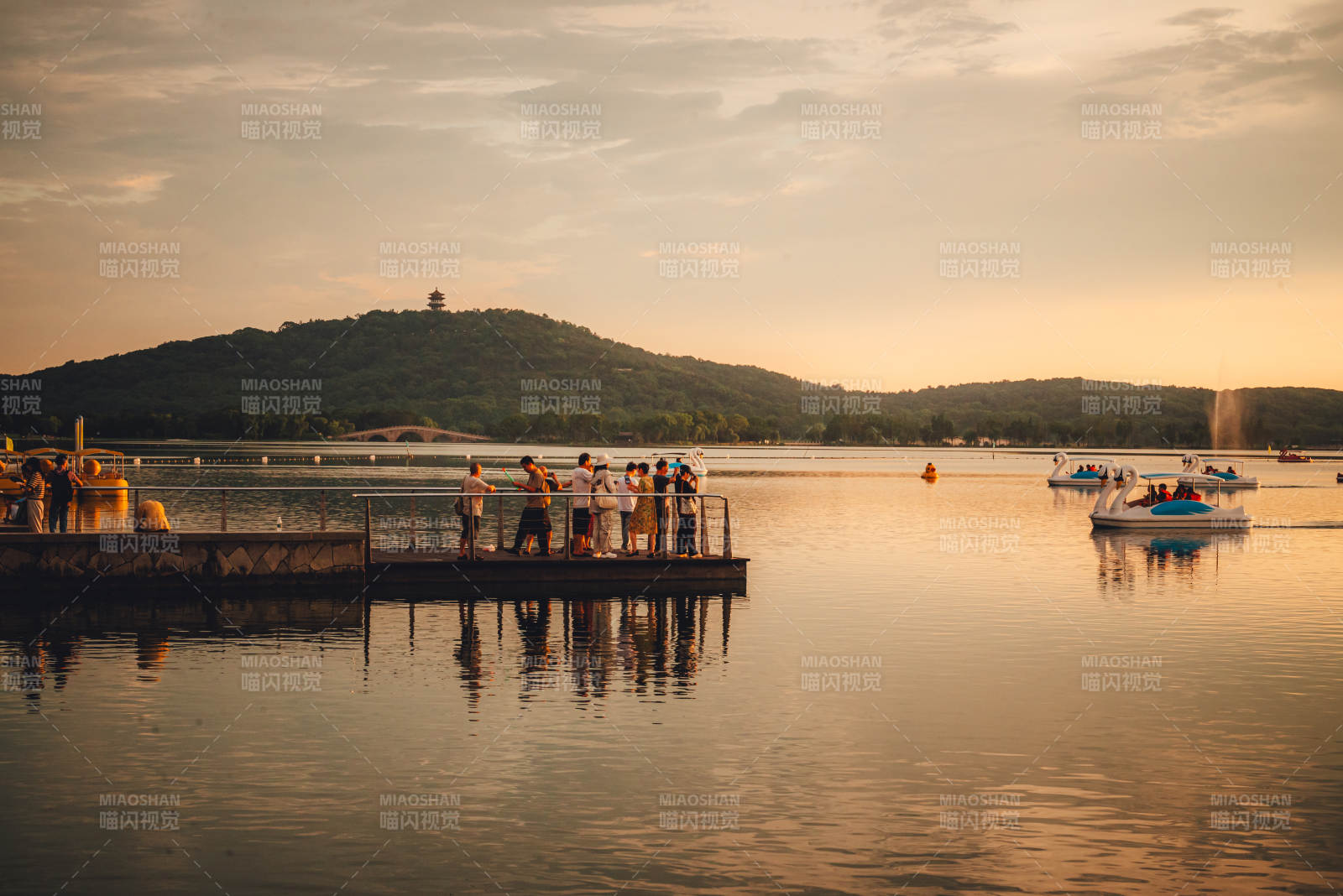 湖畔夕阳 游人泛舟图片