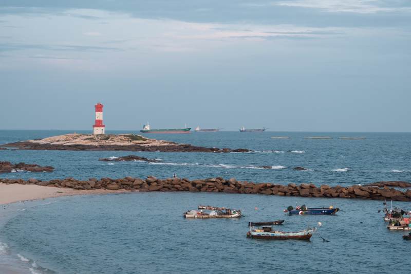 海边灯塔与渔船静谧景致图片