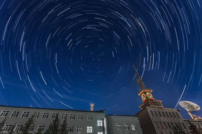 星轨夜空下的建筑群图片