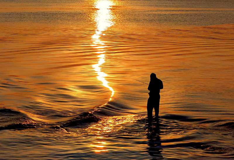 夕阳下的渔者剪影图片