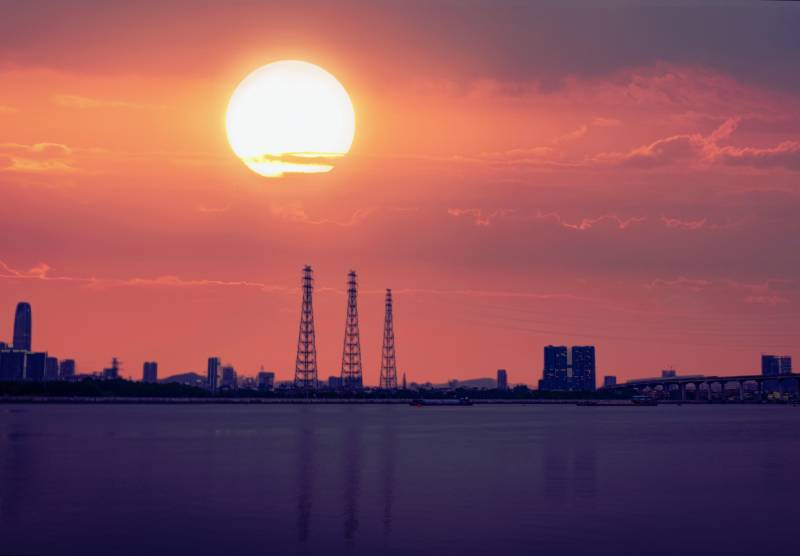 夕阳下的河边城市剪影图片