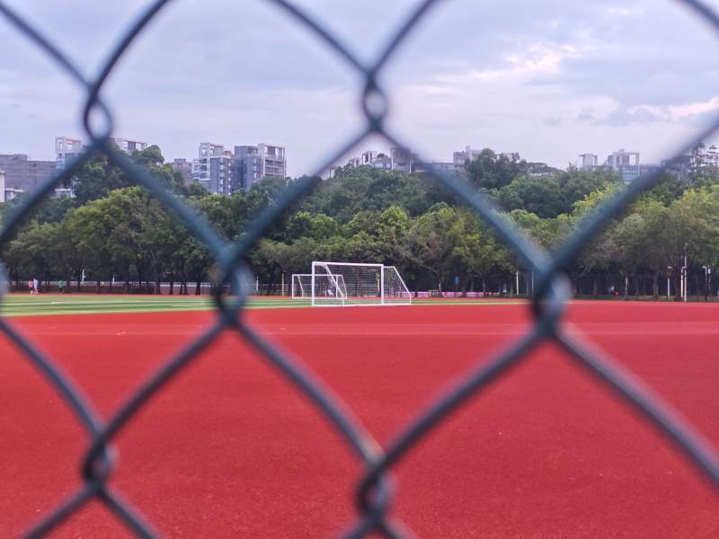 围网后的红色跑道与足球门图片