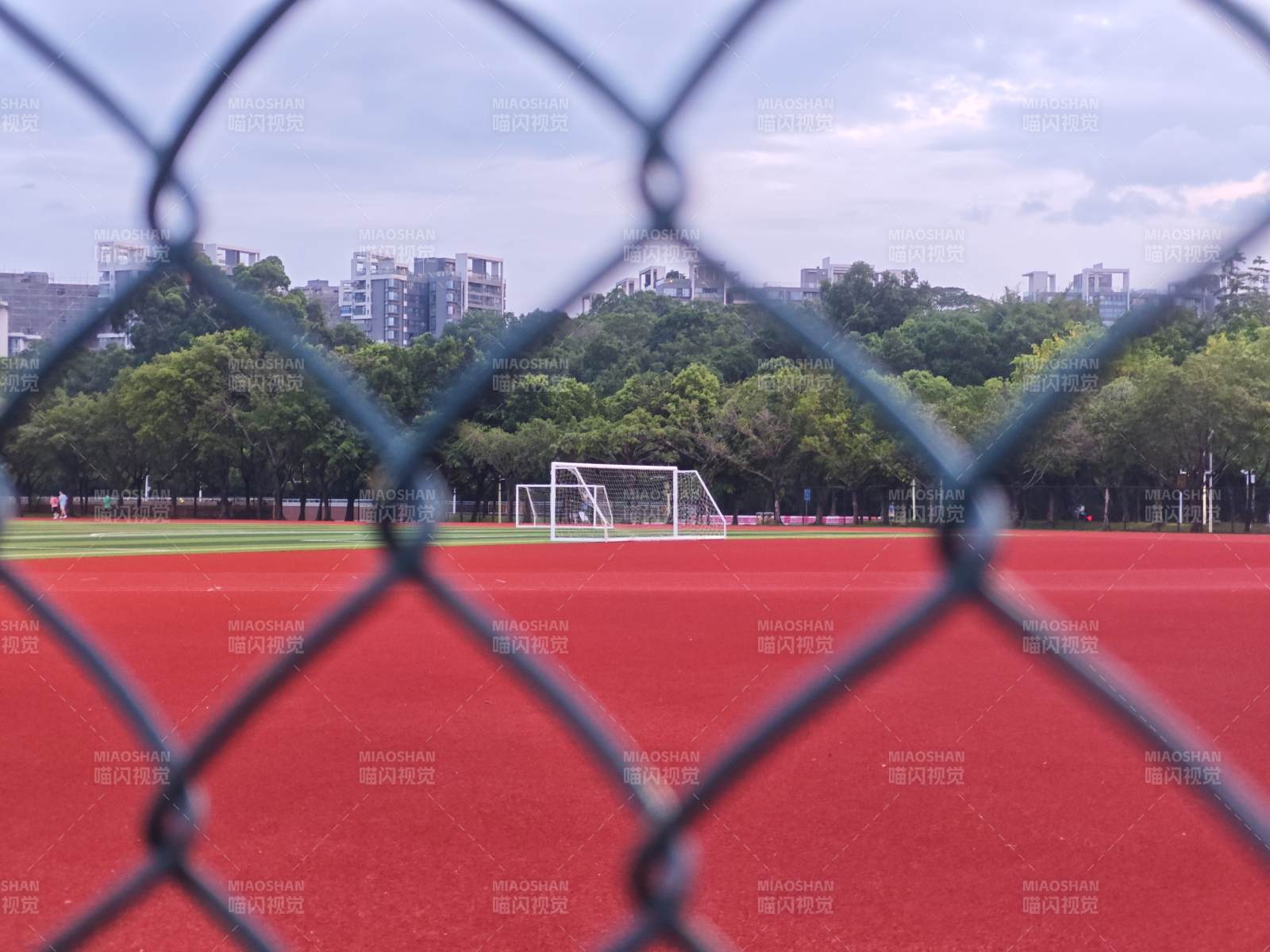 围网后的红色跑道与足球门图片